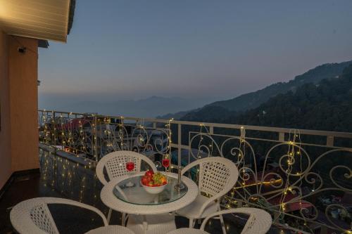 a balcony with chairs and a table with a bowl of fruit at Super Hotel by Perfectstayz Mall Road in Mussoorie