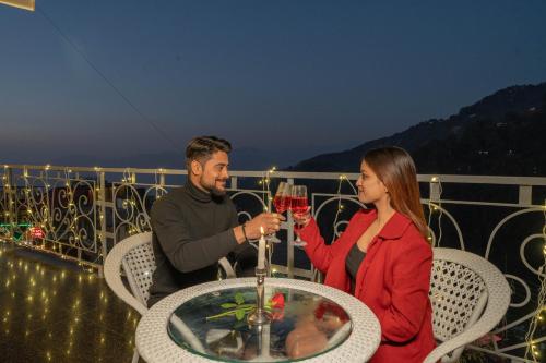 a man and a woman sitting at a table with wine glasses at Super Hotel by Perfectstayz Mall Road in Mussoorie