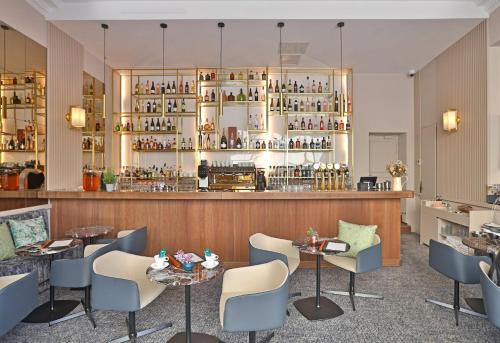 a restaurant with tables and chairs and a bar at Negrecoste Hôtel & Spa in Aix-en-Provence
