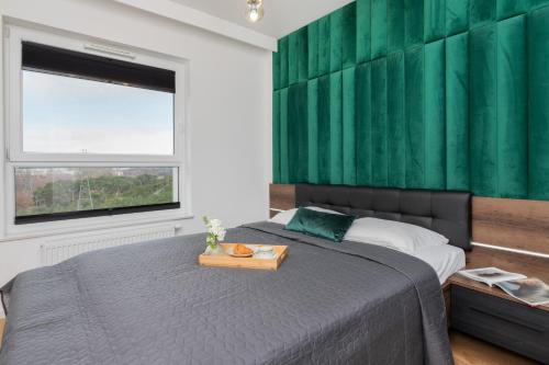 a bedroom with a bed with a green wall at 9th Floor Green and Grey Apartment in Gdańsk Brzeźno with Two Bedrooms and Parking by Renters in Gdańsk