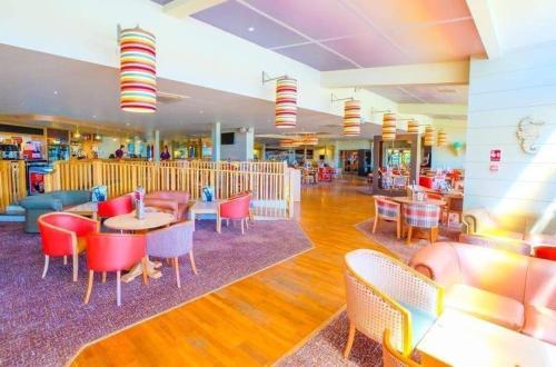 a restaurant with tables and chairs in a mall at Beautiful holiday 3 bed Home Camber-sands in Camber