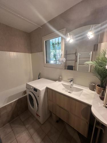 une salle de bain avec une machine à laver et un lavabo dans l'établissement Appartement T2-48M2 ā Santa Lucia Saint Raphaël, à Saint-Raphaël