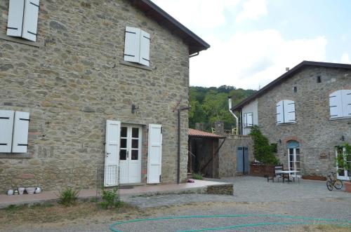 a stone house with white doors and a patio at Locanda di Campagna in Mulazzo