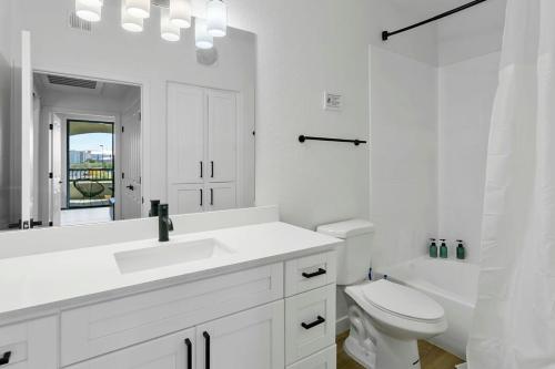 La salle de bains blanche est pourvue d'un lavabo et de toilettes. dans l'établissement CozySuites Glendale by the stadium w pool 09, à Glendale