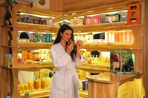 a woman standing at a counter in a cosmetics store at Negrecoste Hôtel & Spa in Aix-en-Provence