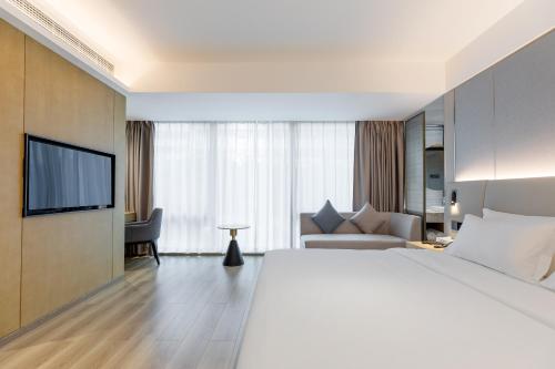 深セン市にあるMaans Hotel - Shenzhen University Science Parkの大型ベッドとテレビが備わるホテルルームです。