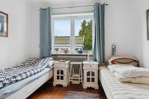 two beds in a room with a window at Bokrsvej 10, 9340 Asaa in Aså