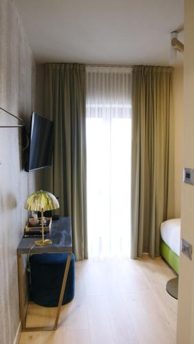 a hotel room with a bed and a table with a lamp at Hotel Battisti 31 in Brescia
