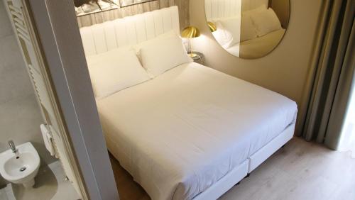 a bedroom with a bed with a sink and a mirror at Hotel Battisti 31 in Brescia