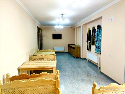 a room with four beds and a television and a room with dresses at Antique Hotel Rizvan in Bukhara