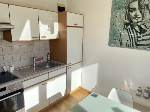 - une cuisine avec des placards blancs et un évier dans l'établissement Relax Holidays, à Rheinheim