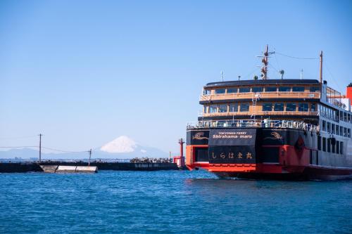 a cruise ship in the water with a mountain in the background at 海都-kaito- TOKYOBAY in Futtsu