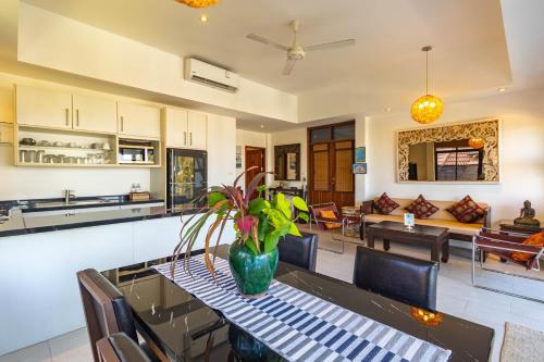 a kitchen and living room with a table and chairs at Kamala Beach Estate Resort - SHA Extra Plus in Kamala Beach