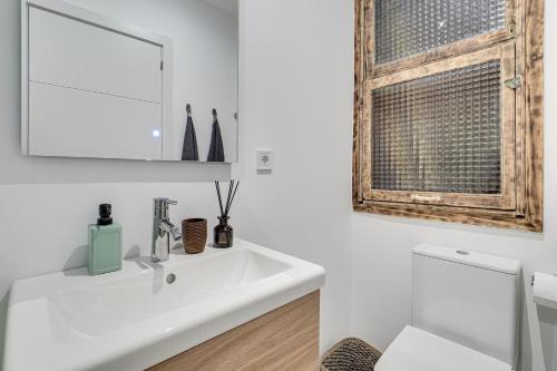 a bathroom with a white sink and a window at Stylish BORN in Barcelona