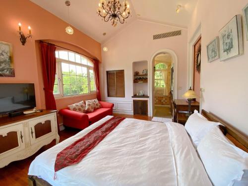 a bedroom with a large bed and a tv at My Chateau Resort in Kenting