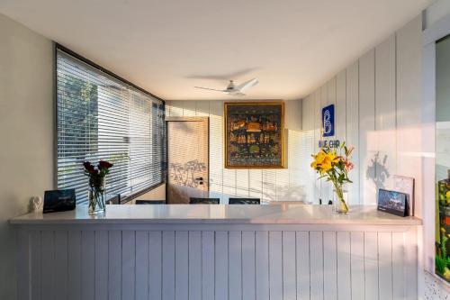 a kitchen with a counter with flowers in vases at Hotel Blue Chip By Downtown - Near Udaipur Airport in Dabok