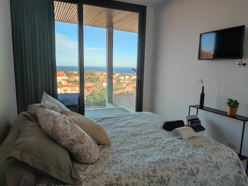a bedroom with a bed with a view of the ocean at La sentinelle du cap Bear in Port-Vendres