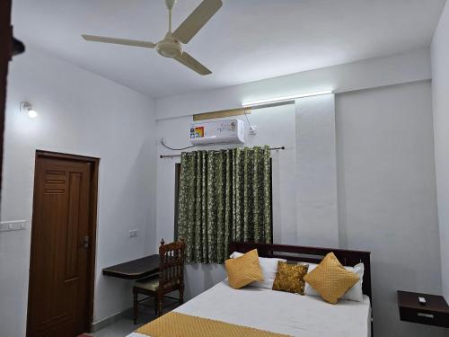 1 dormitorio con 1 cama y ventilador de techo en ZEAL HOMES AND APARTMENTS 2 KOOTHATTUKULAM, en Kuttāttukulam