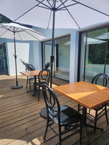 two tables and chairs with umbrellas on a deck at Le Bamboo Guest House And Boat Cruise in Hartbeespoort