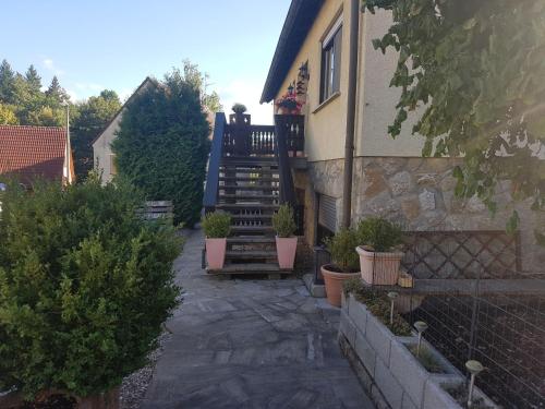 ein Haus mit einer Treppe mit Topfpflanzen darauf in der Unterkunft Ferienwohnung Reblaus in Markt Einersheim