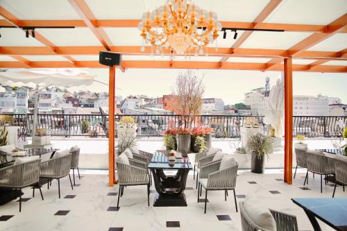 a patio with a chandelier and tables and chairs at The Western Hill Hotel in Da Lat