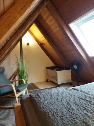 a bedroom with a bed and a chair in a attic at Altstadt Appartements in Landsberg am Lech