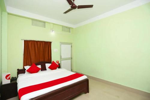 1 dormitorio con 1 cama con almohadas rojas en Goroomgo Somnath Puri, en Puri