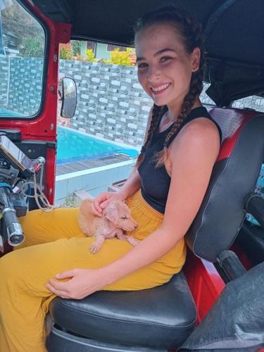 a woman sitting in a vehicle holding a smallanimal at Andorra Tourist Resort Anuradhapura in Anuradhapura