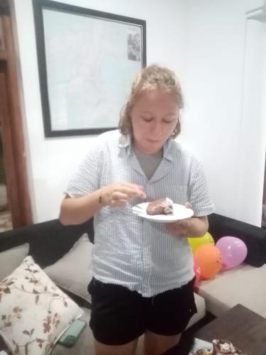 a woman eating a piece of cake on a plate at Andorra Tourist Resort Anuradhapura in Anuradhapura