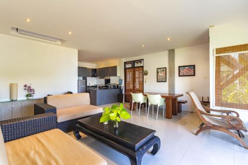 a living room with a couch and a table at Kamala Beach Estate Resort - SHA Extra Plus in Kamala Beach