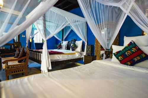 um quarto com 2 camas e cortinas brancas em Jafferji House em Zanzibar City