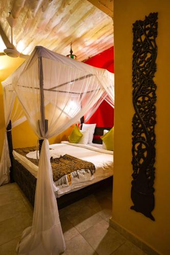a bedroom with a bed with a canopy at Jafferji House in Zanzibar City