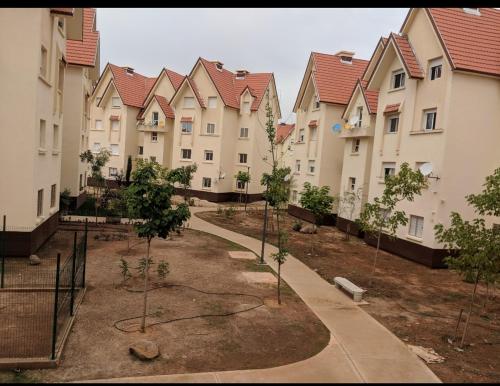 a row of apartment buildings with trees in the courtyard at Appartement Au jardin in Ifrane