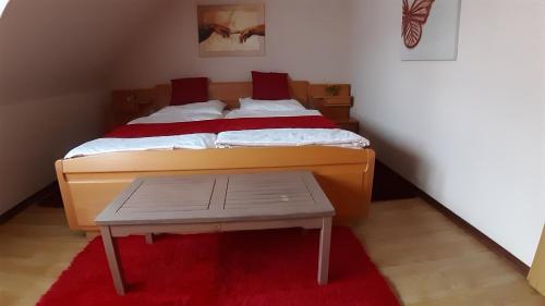 a bedroom with a large bed with a red rug at Ferienwohnung Sommerfeld in Bispingen