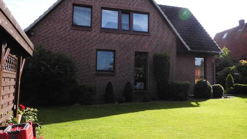a red brick house with a green yard at Ferienwohnung Sommerfeld in Bispingen