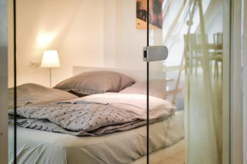 a glass room with a bed with pillows on it at 5 Secret escape apartment above Stuttgart in Stuttgart
