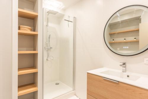 une salle de bain avec une douche, un lavabo et un miroir dans l'établissement Fantastic Family Apartment - 20min from city center, au Kremlin-Bicêtre