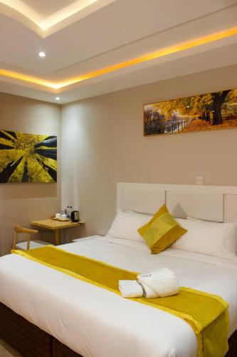 ein Schlafzimmer mit einem großen Bett mit zwei Handtüchern darauf in der Unterkunft Milestone Hotels in Lusaka