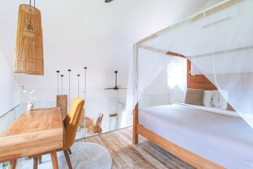 a bedroom with a bed and a wooden desk at Sun & Moon Villa in Canggu