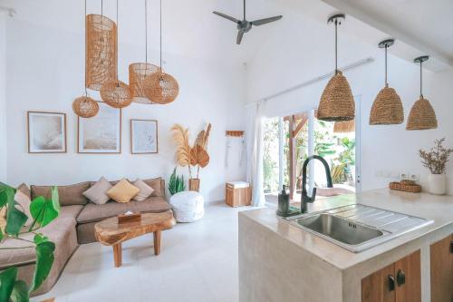 a kitchen and living room with a couch and a sink at Sun & Moon Villa in Canggu