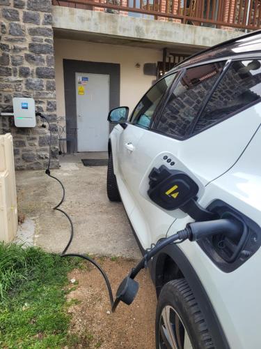 a white car is plugged into a car charger at Chambres d'hôtes du Bistrot d'ici in Saint-Saturnin