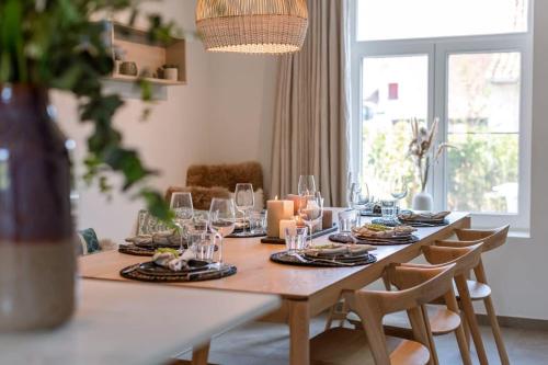 布魯日的住宿－Quick - Charming double room at ranch "De Blauwe Zaal"，餐桌,上面有盘子和玻璃杯