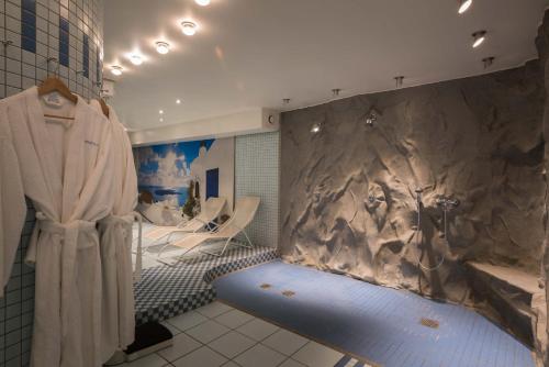 a bathroom with a stone wall with a shower stall at Hotel The Rose by Goeres in Luxembourg