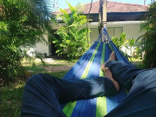a man laying in a hammock in front of a house at Digital Nomads in Weligama
