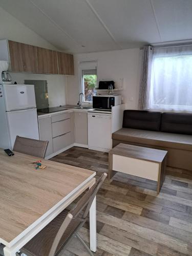 a kitchen with a couch and a table in a room at Camping du Domaine de la Forge in La Teste-de-Buch