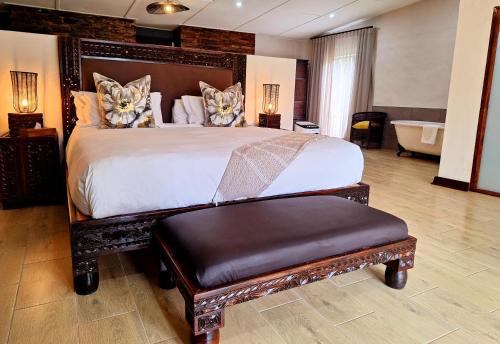 a bedroom with a large bed and a bath tub at Tala Collection Game Reserve in Silverton