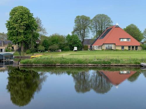 的住宿－De Middelste Dam，河边有红色屋顶的房子
