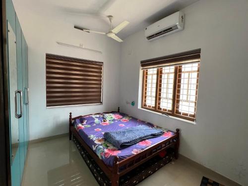 a bedroom with a bed in a room with a fan at Happy Villa Homestay - 2 in Chelakara