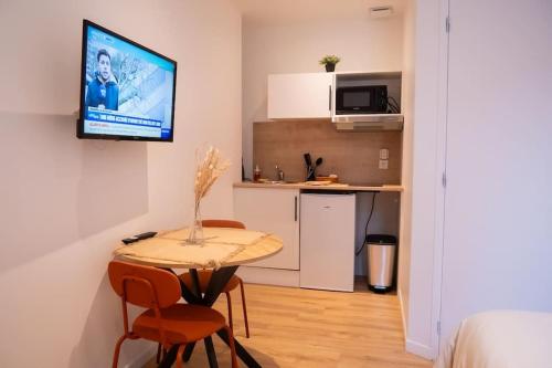 une petite pièce avec une table et une cuisine dans l'établissement Studio Paisible 2pers wifi gare, à Saint-Quentin