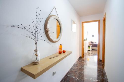 a hallway with a mirror and a vase on a shelf at Luna Apartment by A3Rentals in Armilla